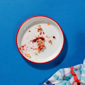 A plate with a few crumbs on it left over from a Bakewell Slice.