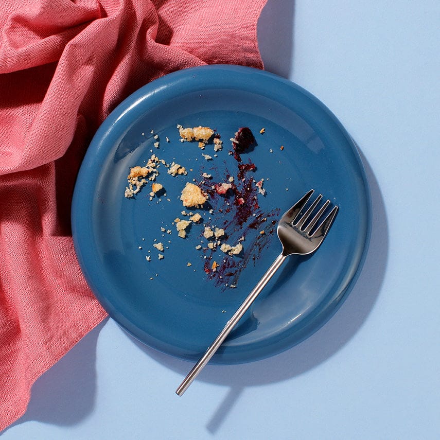 Empty plate with crumbs and pastry pieces from Blueberry and Lemon Muffin Tart.