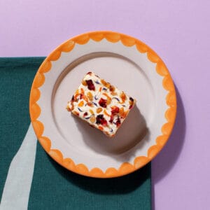 An overhead view of a slice of our Carrot Cake on a plate - We sell these and other baked goods to coffee shops.
