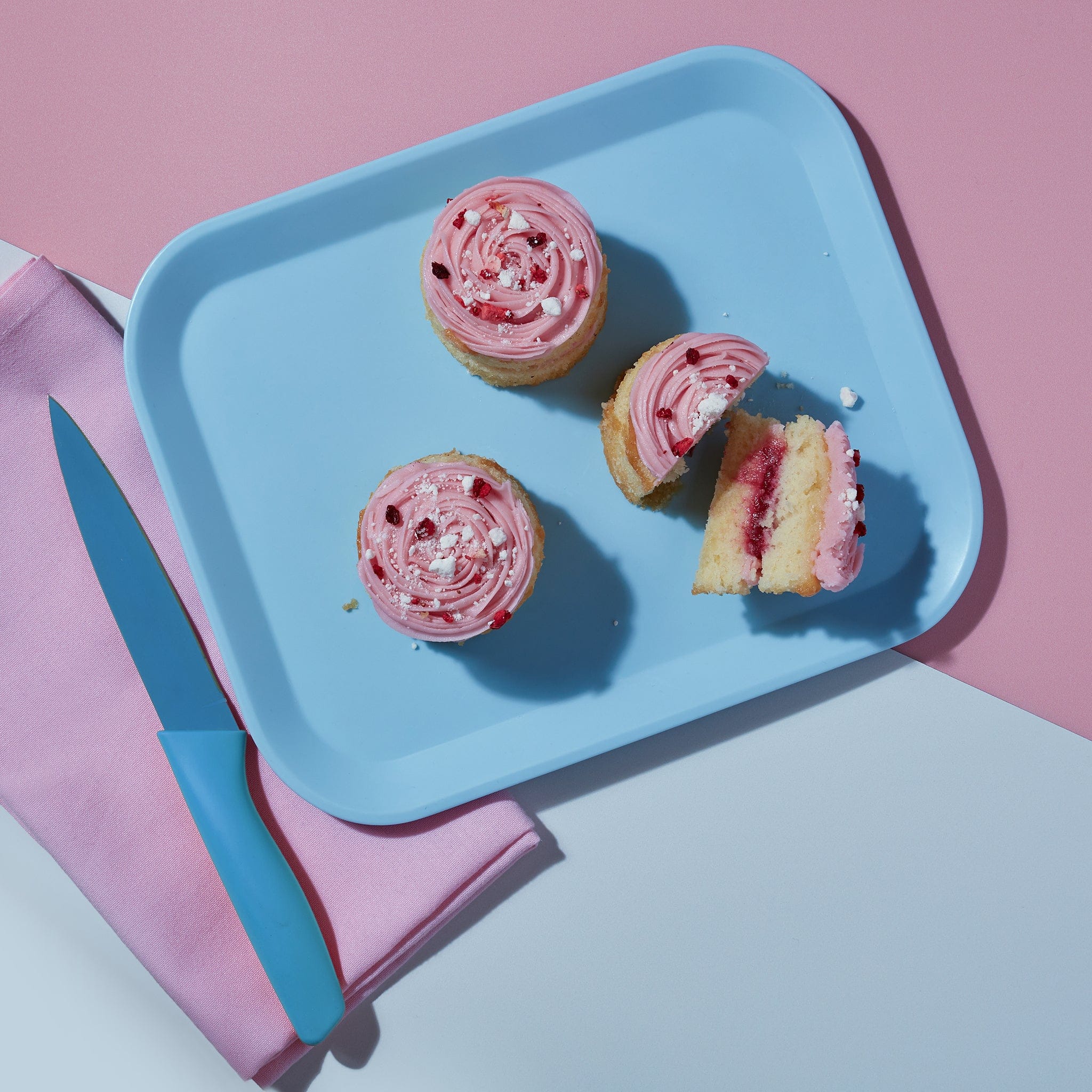 An overhead view of three Eaton Mess Mini Cakes from Cake Club on a blue plate.