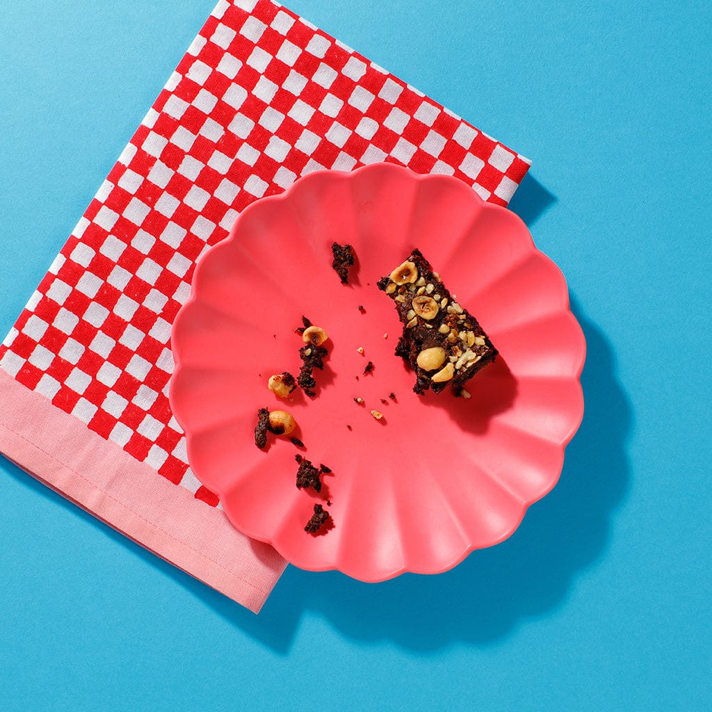 An overhead view of a plate containing a half eaten Praline Melt Brownie and some crumbs.