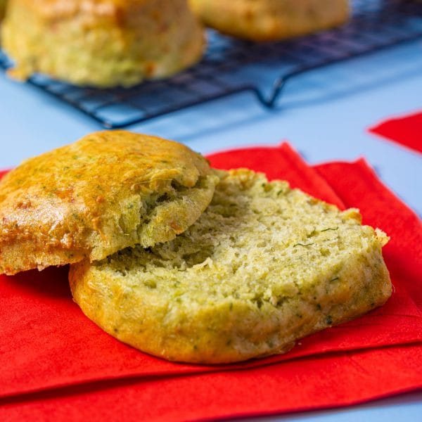 Spinach and Feta Scone cut open on a rack with a red background.