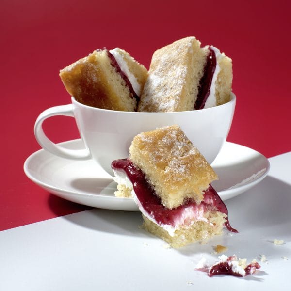 Victoria Sponge Traycake slices stacked in a teacup, with jam and cream filling, Cake Club.