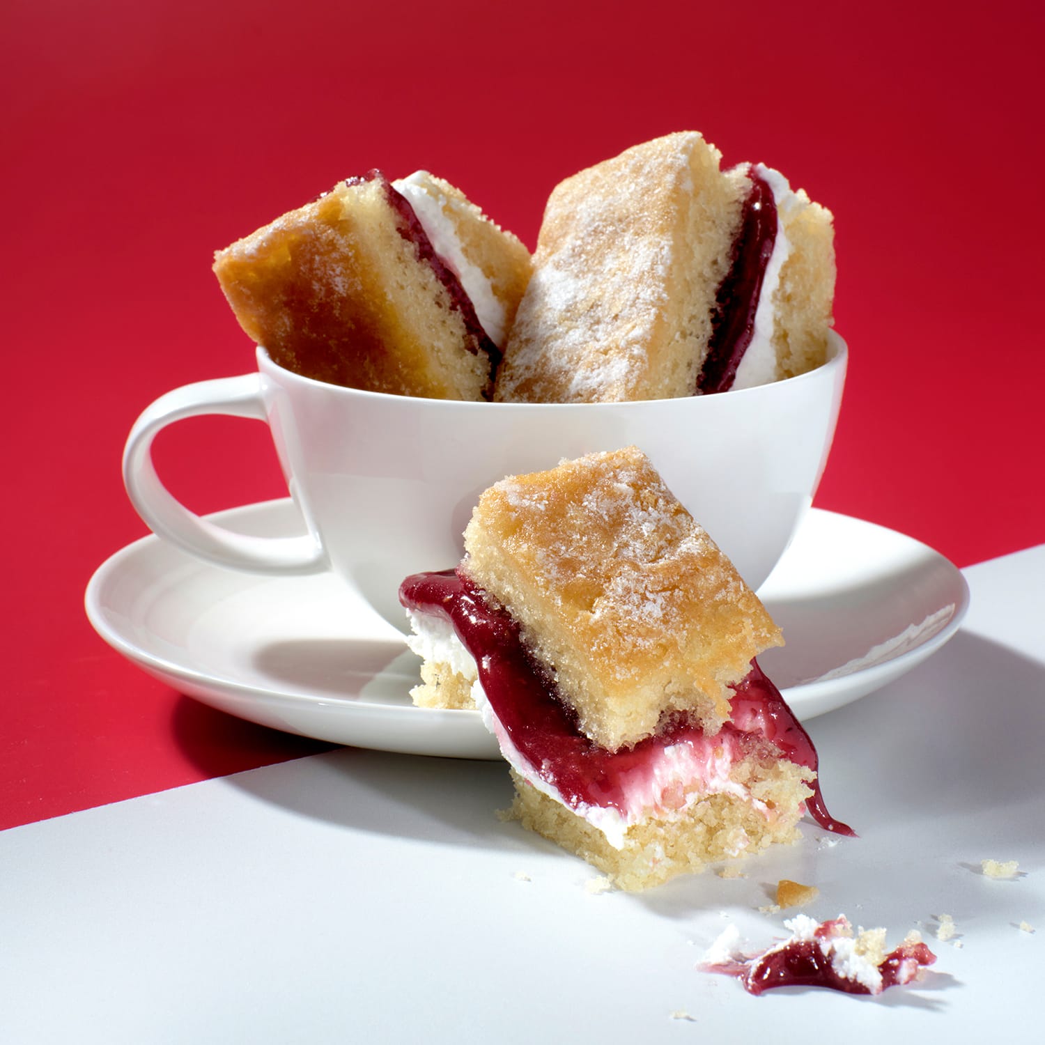 Victoria Sponge Traycake slices stacked in a teacup, with jam and cream filling, Cake Club.