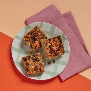 Roasted Hazelnut Flapjack pieces arranged on a plate with a pink napkin.