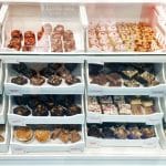 Cake display cabinet filled with traybakes, brownies, blondies, muffins and pastries, showing variety and quality from a professional cake supplier.